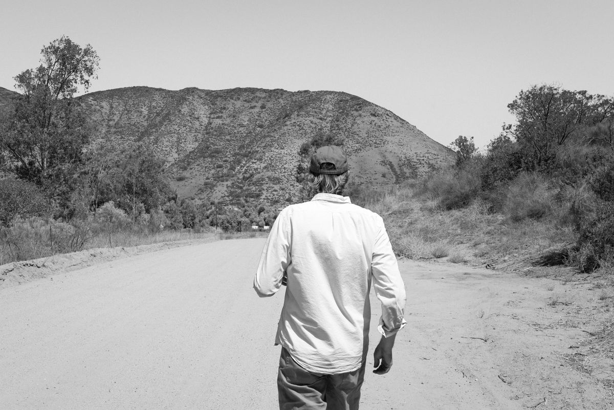The proprietor, from behind, desert and mountains beyond.